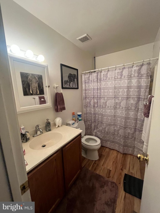 bathroom with vanity, toilet, a shower with curtain, and hardwood / wood-style floors