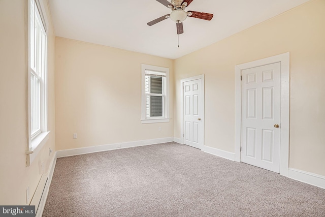 unfurnished bedroom featuring multiple windows, ceiling fan, and carpet flooring