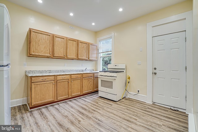 kitchen with white appliances and light hardwood / wood-style floors