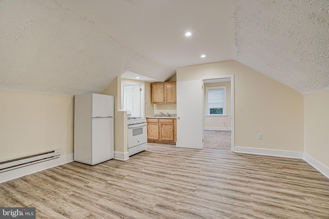 kitchen featuring lofted ceiling, white appliances, light wood-type flooring, and a textured ceiling