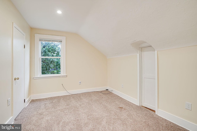 bonus room with carpet floors and vaulted ceiling