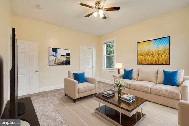 living room featuring carpet floors, ornamental molding, and ceiling fan