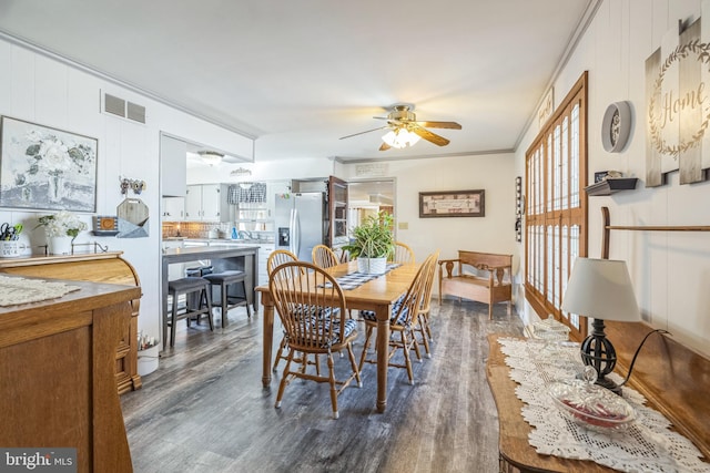 dining room with crown molding, dark hardwood / wood-style flooring, and ceiling fan