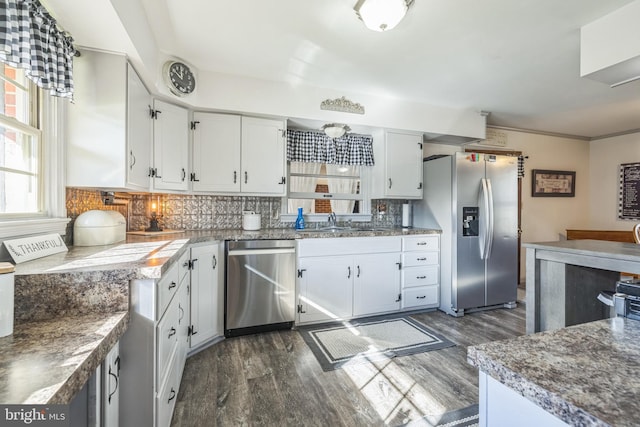 kitchen featuring white cabinets, appliances with stainless steel finishes, dark wood-type flooring, and tasteful backsplash