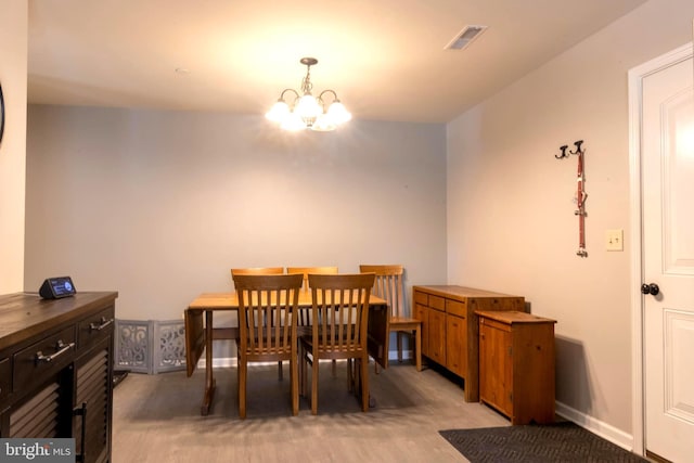 dining area with a chandelier and light colored carpet