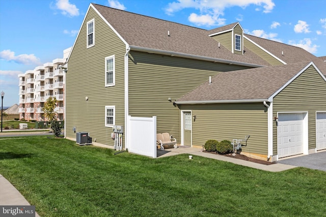 view of property exterior with a yard, central AC unit, and a garage