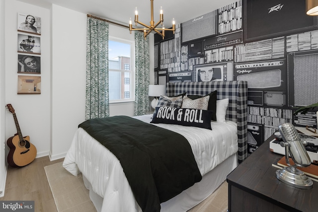 bedroom featuring light wood-type flooring and a notable chandelier