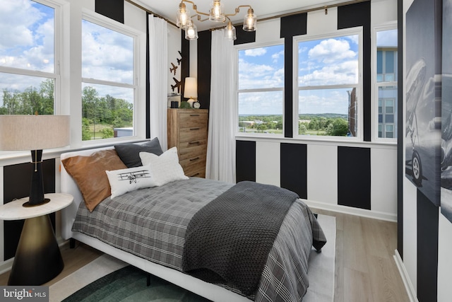 bedroom featuring an inviting chandelier and hardwood / wood-style floors