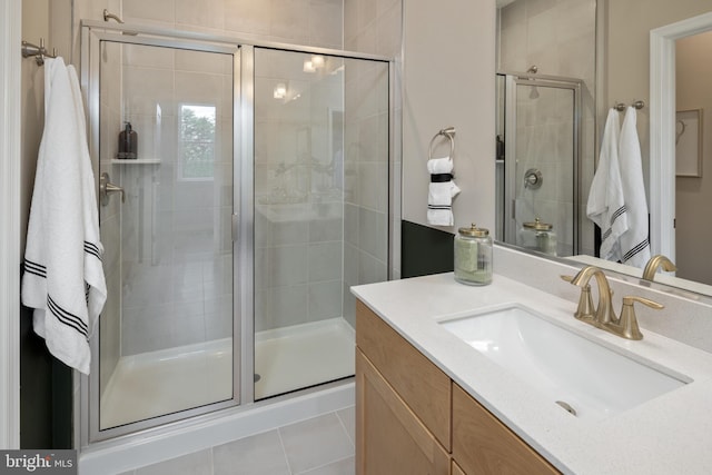 bathroom featuring vanity, a shower with shower door, and tile patterned flooring