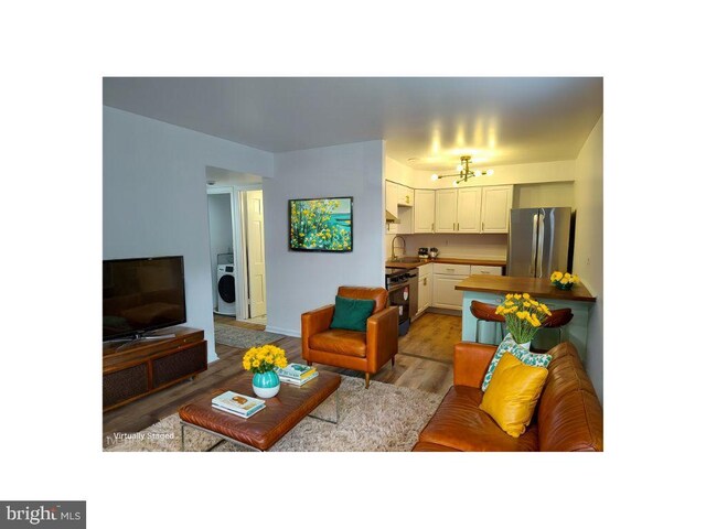 2004 38th St SE Unit 202, Washington, DC 20020 - living area with light wood-style floors and washer / dryer