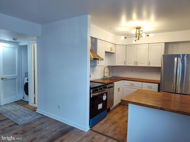 2004 38th St SE Unit 202, Washington, DC 20020 - kitchen featuring a chandelier, wood counters, stainless steel appliances, washer / dryer, and extractor fan