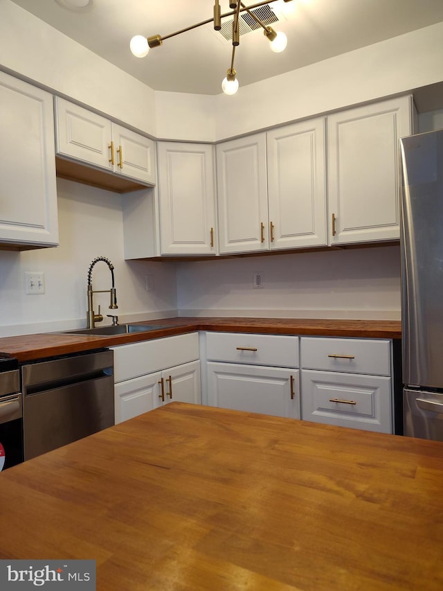 2004 38th St SE Unit 202, Washington, DC 20020 - kitchen with butcher block countertops, appliances with stainless steel finishes, a sink, and white cabinets