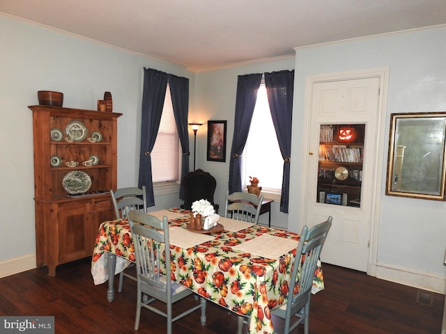 dining space with dark wood-type flooring and ornamental molding