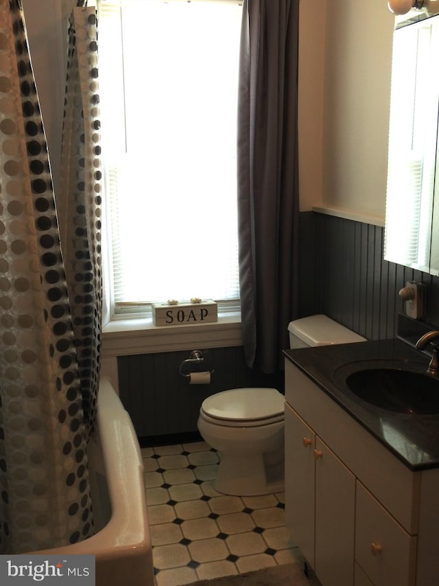 full bathroom with shower / tub combo with curtain, vanity, and toilet