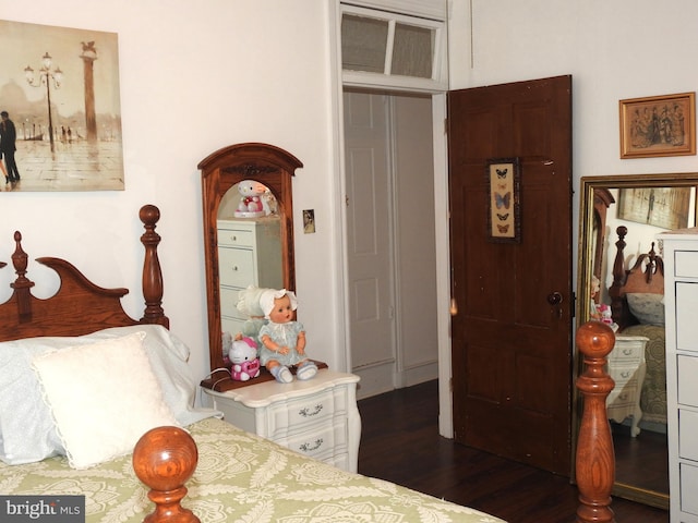 bedroom with dark wood-type flooring and a closet