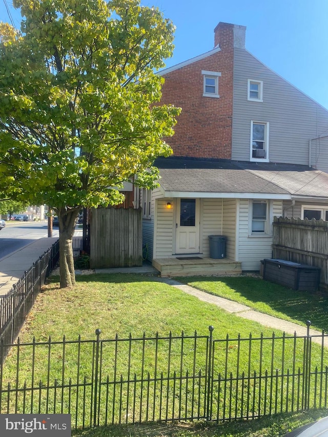 back of house featuring a lawn