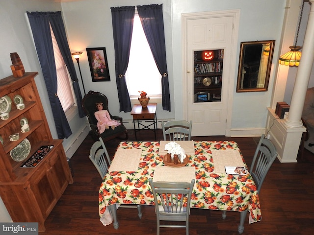 dining space featuring decorative columns and dark hardwood / wood-style flooring