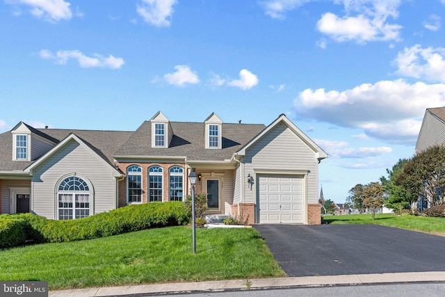 cape cod house with a front yard and a garage