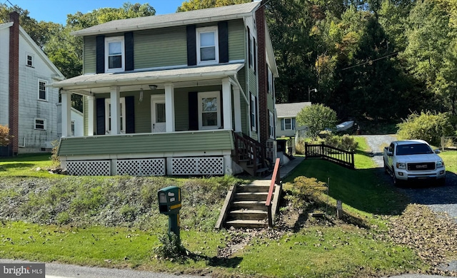 view of front facade with a front yard and covered porch