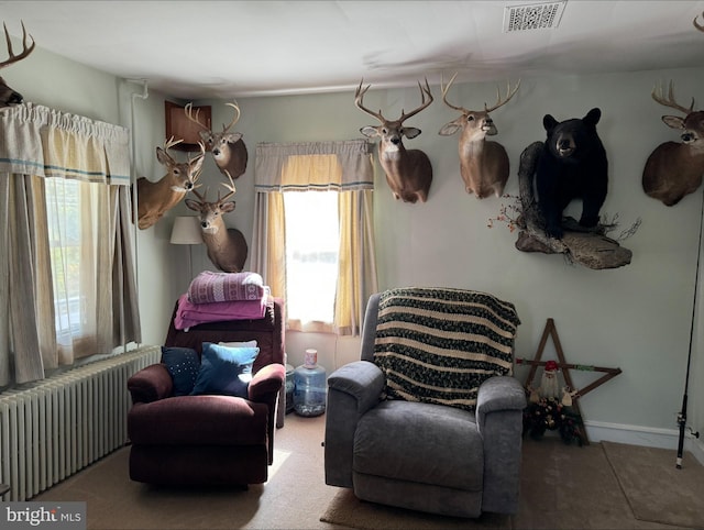 sitting room featuring radiator and carpet