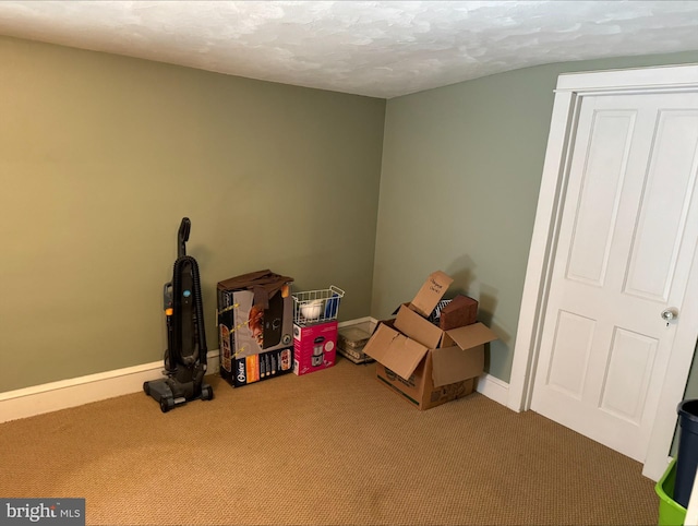 recreation room featuring carpet floors and a textured ceiling