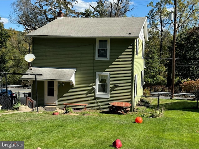 rear view of property featuring a lawn