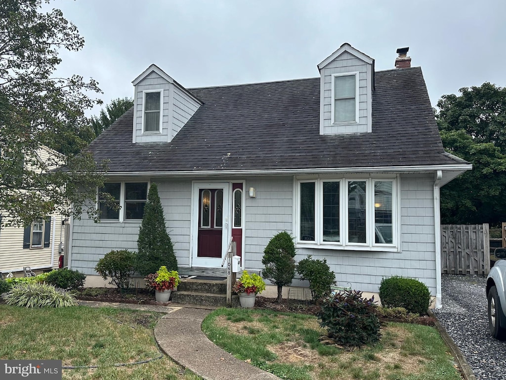 cape cod house with a front lawn