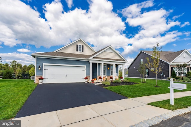 view of front of property with a garage, a porch, and a front lawn