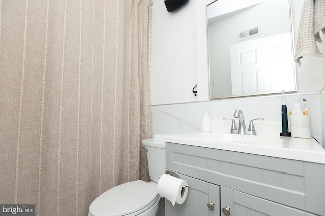 bathroom with toilet, curtained shower, vanity, and tasteful backsplash