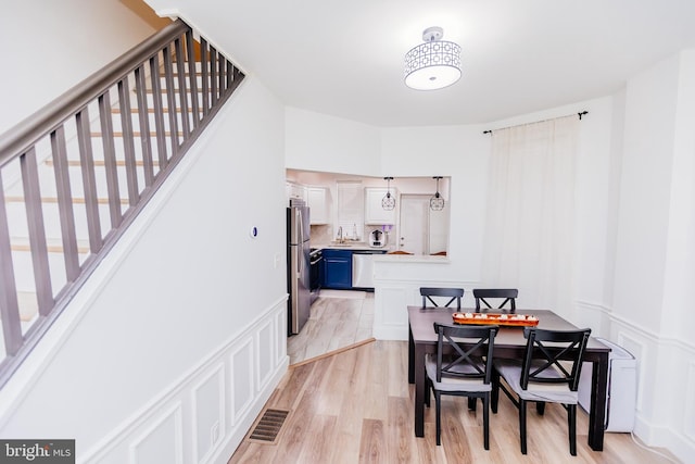 dining area with sink and light hardwood / wood-style flooring