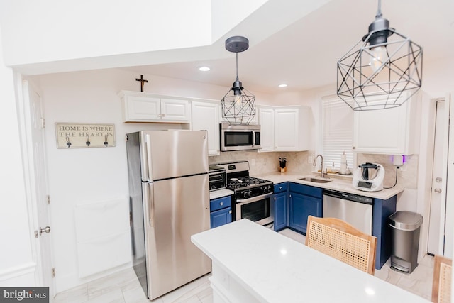 kitchen with white cabinetry, appliances with stainless steel finishes, decorative light fixtures, sink, and blue cabinets