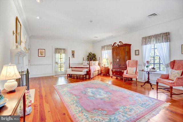 bedroom with light hardwood / wood-style floors and ornamental molding