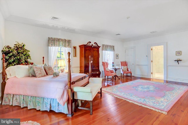 bedroom with wood-type flooring and ornamental molding