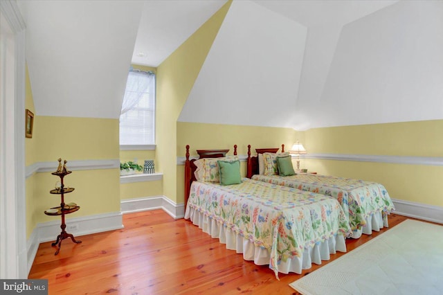 bedroom with wood-type flooring and lofted ceiling