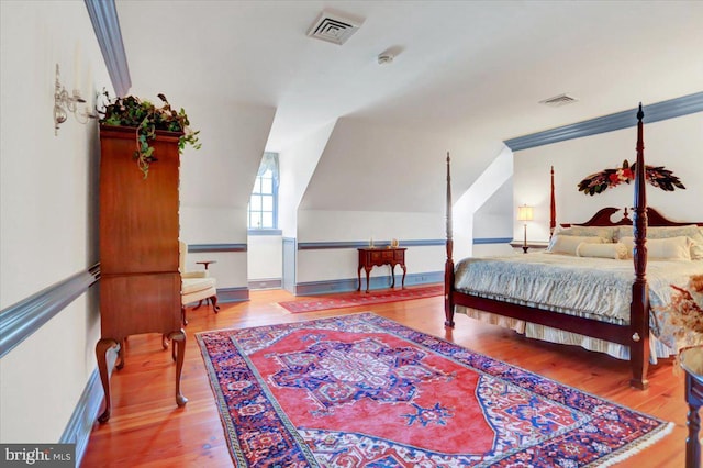 bedroom featuring hardwood / wood-style flooring and lofted ceiling