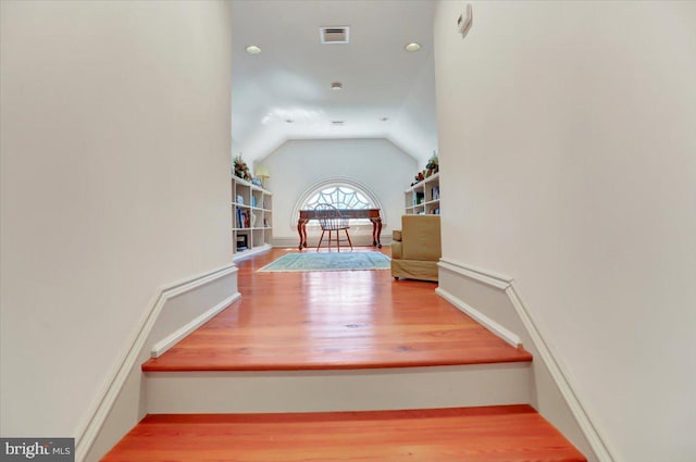 stairs featuring hardwood / wood-style flooring and lofted ceiling