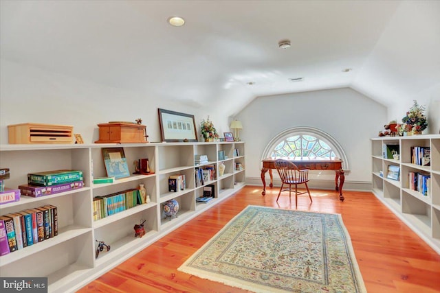 sitting room with wood-type flooring and lofted ceiling