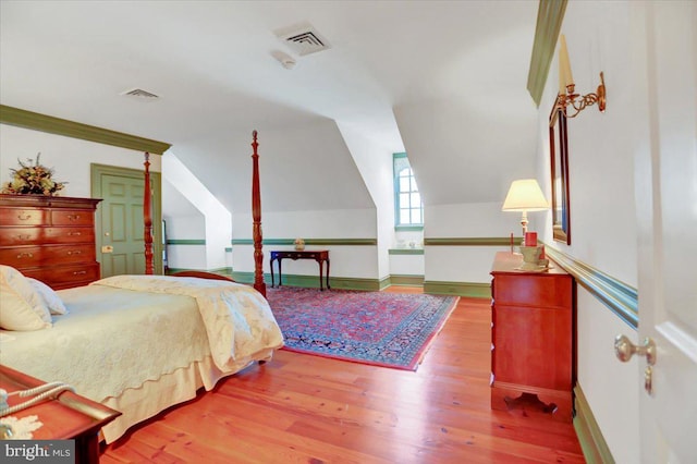 bedroom featuring wood-type flooring and vaulted ceiling