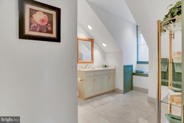 bathroom featuring vanity and lofted ceiling