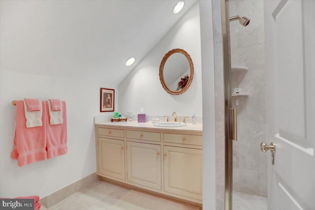 bathroom featuring vanity, vaulted ceiling, and a shower with shower door