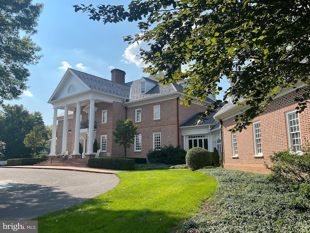 greek revival inspired property featuring a front yard