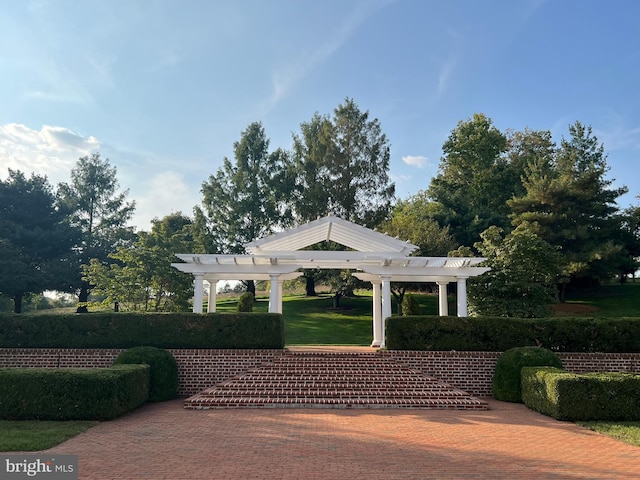 view of home's community with a yard and a pergola