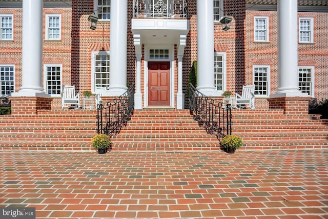 doorway to property with a balcony and covered porch