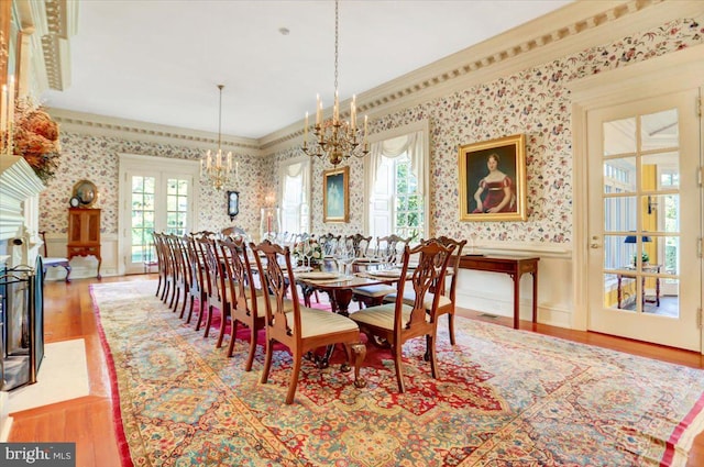 dining area featuring a chandelier, hardwood / wood-style floors, french doors, and a wealth of natural light