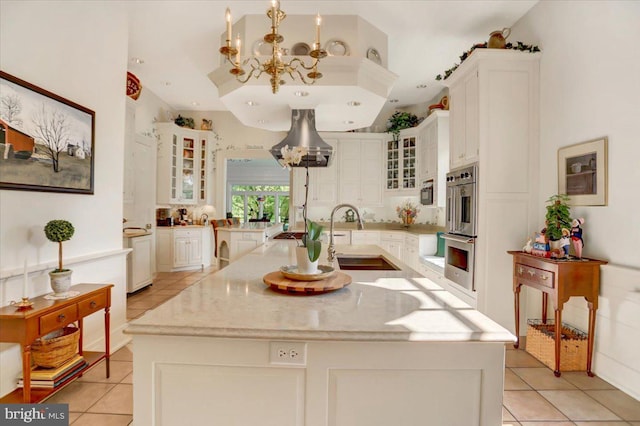 kitchen featuring sink, stainless steel double oven, pendant lighting, a center island with sink, and light tile patterned floors