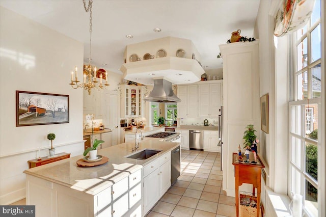 kitchen featuring plenty of natural light, sink, a kitchen island with sink, and range hood