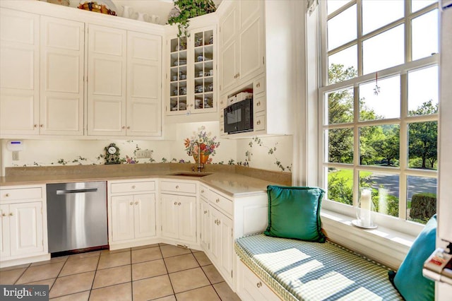 kitchen featuring dishwasher, sink, white cabinetry, and light tile patterned flooring