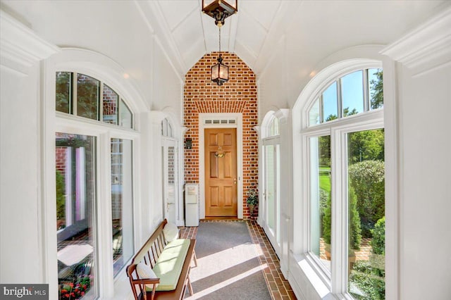 carpeted entrance foyer featuring plenty of natural light and lofted ceiling