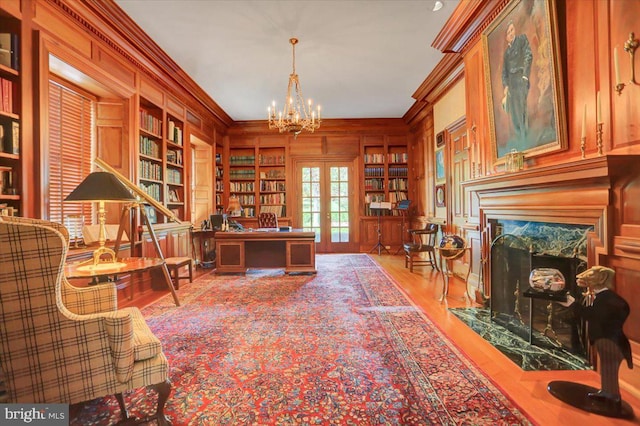 office with crown molding, built in features, french doors, and light hardwood / wood-style flooring