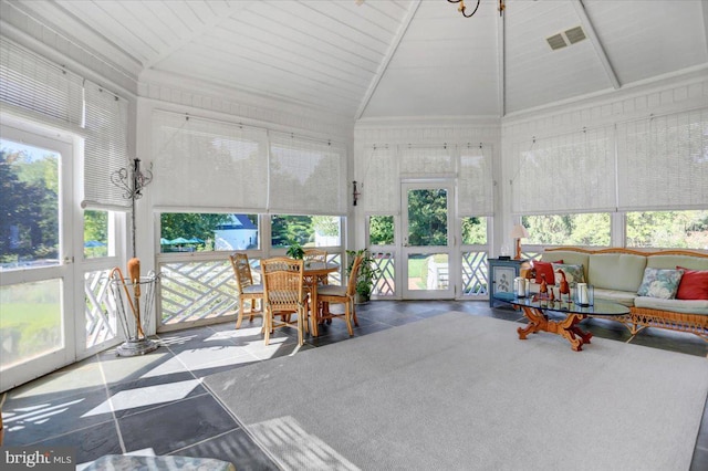 sunroom / solarium featuring a healthy amount of sunlight, wood ceiling, and vaulted ceiling